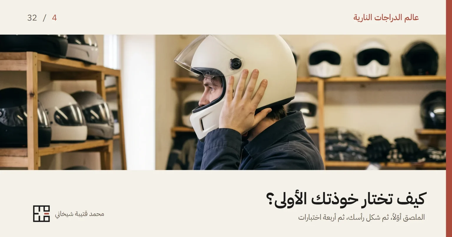 شابٌّ داخل متجر عتاد دراجات نارية يجرّب خوذة كاملة الوجه بلون عاجي، يمسكها بيده وهو يستقرّها على رأسه وواقيها الشفاف مرفوع، ويظهر حاجز الذقن واضحاً في وضع جانبي، وحوله رفوف خشبية عليها خوذات أخرى وقفازات وملابس.