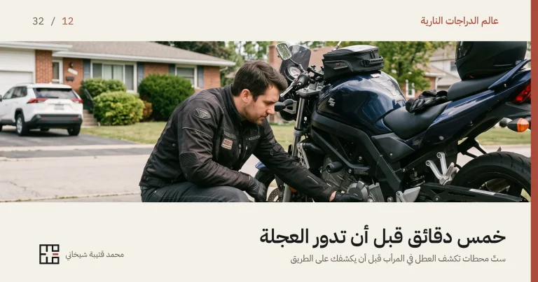 درّاج جاثٍ إلى جانب دراجته النارية في مدخل منزل، يمدّ يده المقفَّزة إلى أسفل الدراجة وعينه على ما يلمسه. الدراجة واقفة على مسندها الجانبي كاملةً، وعلى مؤخّرتها خوذة سوداء مطفأة وحقيبة خزّان صغيرة، وخلفه بيوتٌ وسيارة واقفة في صباحٍ غائم.